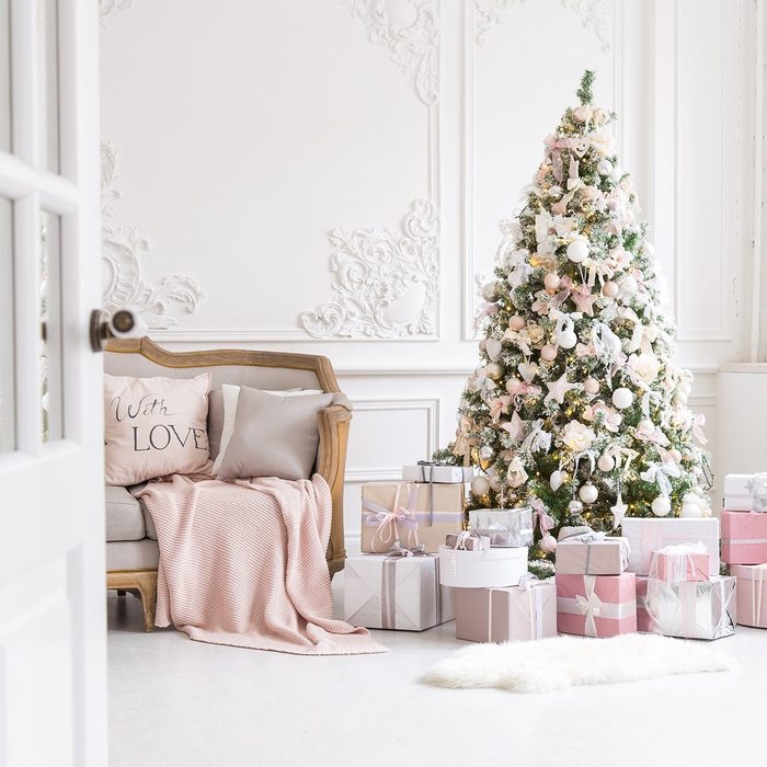 Intérieur de salon de luxe avec canapé décoré chic arbre de Noël, cadeaux, plaid et oreillers