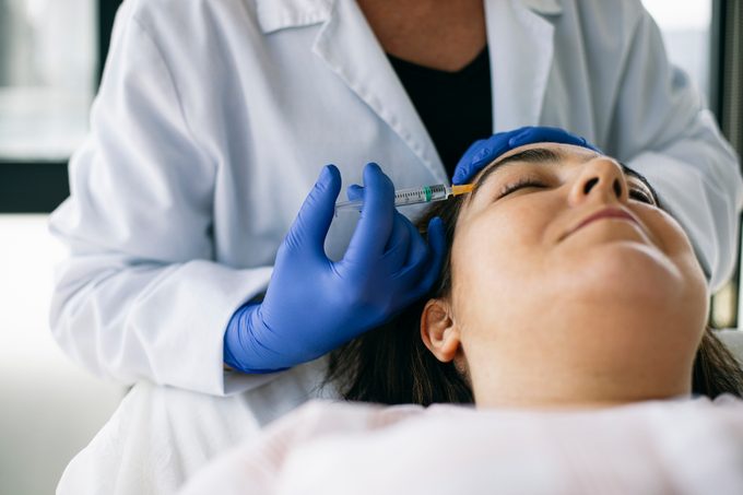 Une femme reçoit du botox dans le visage pour un traitement contre la migraine