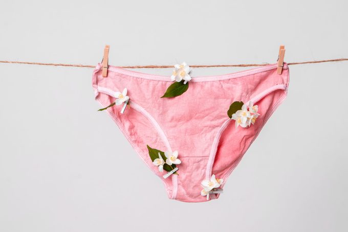 Sous-vêtements roses pour femmes avec des fleurs sur la corde à linge